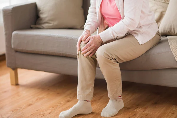 Primo piano della donna anziana con dolore alla gamba a casa — Foto Stock