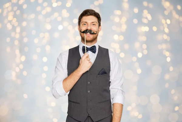 Glücklicher junger Mann mit falschem Schnurrbart auf Party — Stockfoto