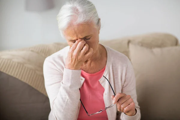 Seniorin mit Brille hat zu Hause Kopfschmerzen — Stockfoto