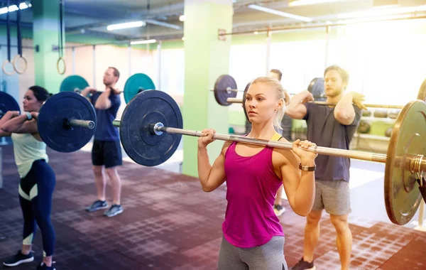 Група людей, що тренуються з барбелами в спортзалі — стокове фото