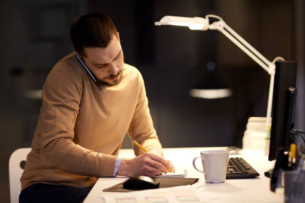 Businessman calling on sartphone at night office — Stock Photo, Image