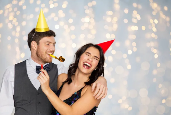 Feliz pareja con ventiladores de fiesta que se divierten — Foto de Stock