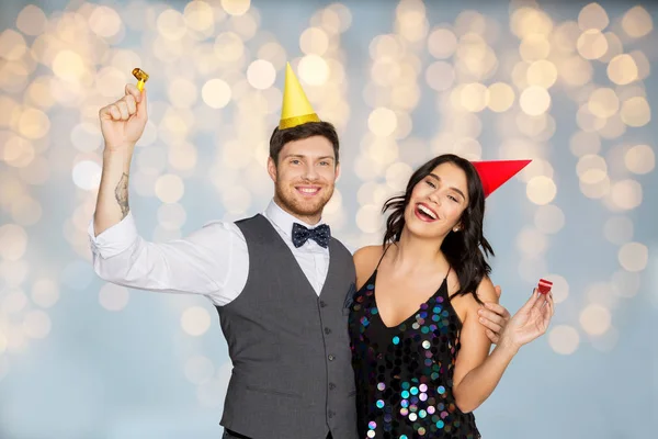 Feliz pareja con ventiladores de fiesta que se divierten — Foto de Stock