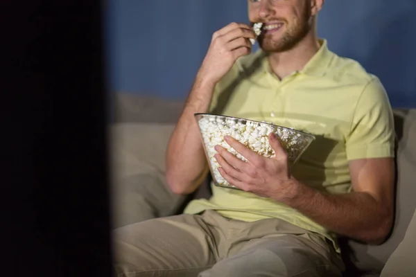 Close up of man with popcorn watching tv at night — Stock Photo, Image