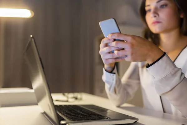 Geschäftsfrau mit Smartphone und Laptop im Büro — Stockfoto