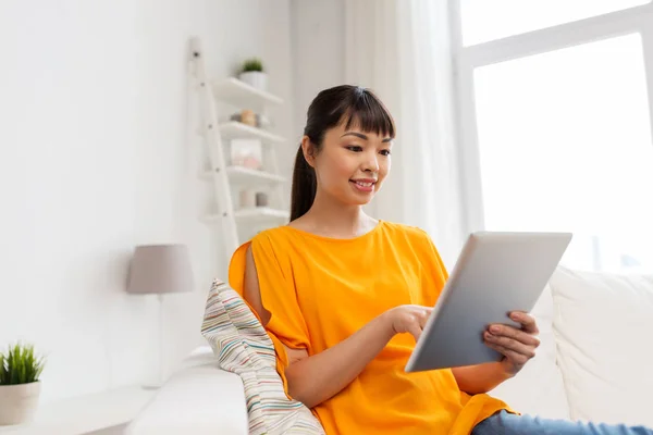 Glad ung asiatisk kvinna med TabletPC hemma — Stockfoto
