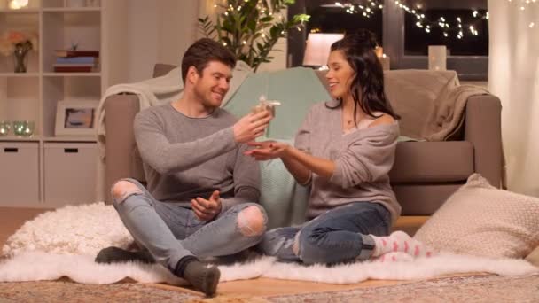 Feliz pareja con caja de regalo en casa — Vídeos de Stock