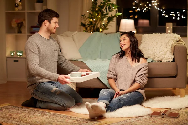 Feliz pareja con comida en la bandeja en casa — Foto de Stock