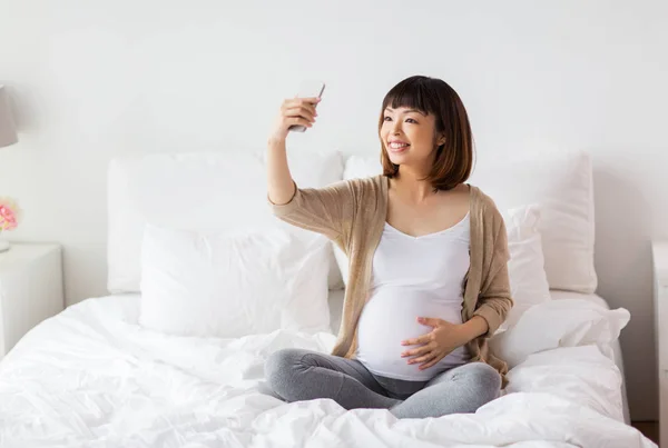 Hamile kadın selfie smartphone tarafından evde alarak — Stok fotoğraf
