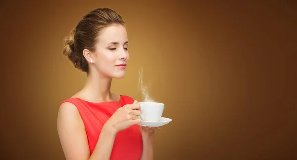 Hermosa mujer en vestido rojo con taza de café — Foto de Stock