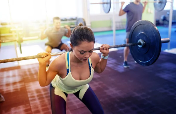 Gruppo di persone che si allenano con i bilancieri in palestra — Foto Stock