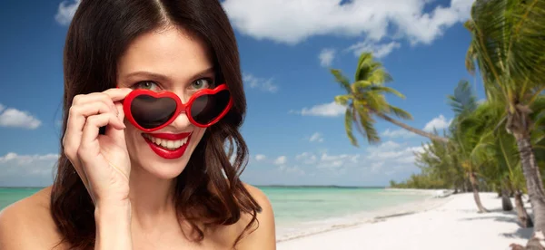 Vrouw in hartvormige tinten op zomer-strand — Stockfoto