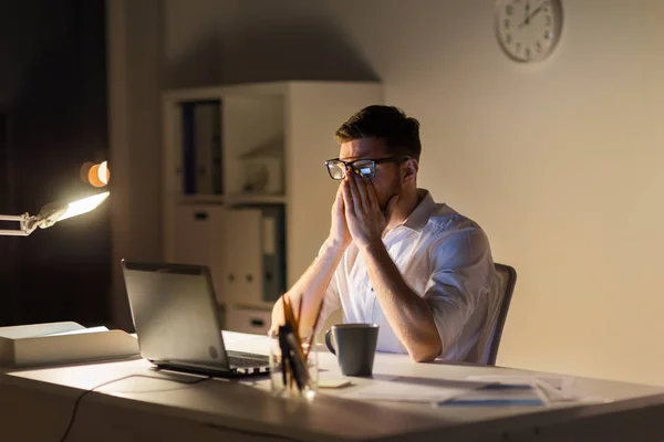 Втомлений бізнесмен з ноутбуком в нічному офісі — стокове фото