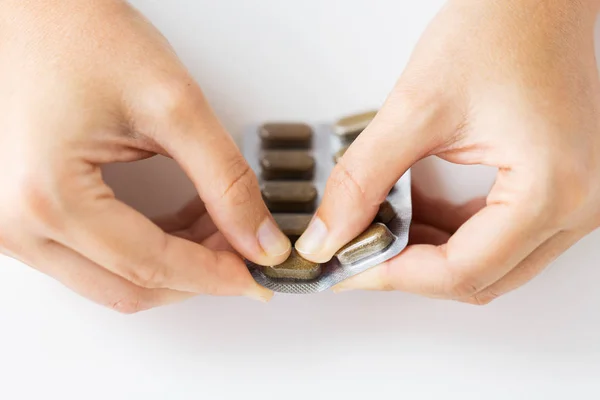 Woman hands opening pack of medicine pills — Stock Photo, Image