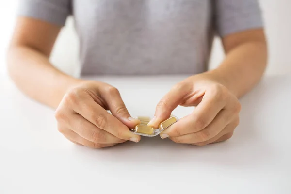 Woman hands opening pack of medicine capsules — Stock Photo, Image