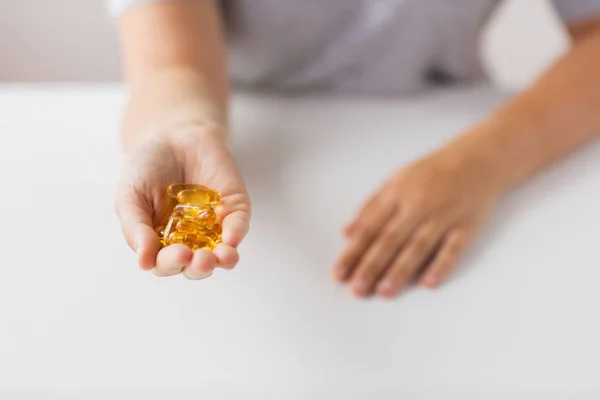 Hand holding cod liver oil capsules — Stock Photo, Image