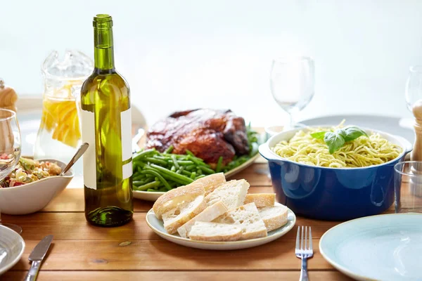 Bottle of wine and food on served wooden table — Stock Photo, Image