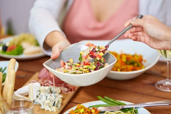 Pessoas comendo salada à mesa com alimentos — Fotografia de Stock