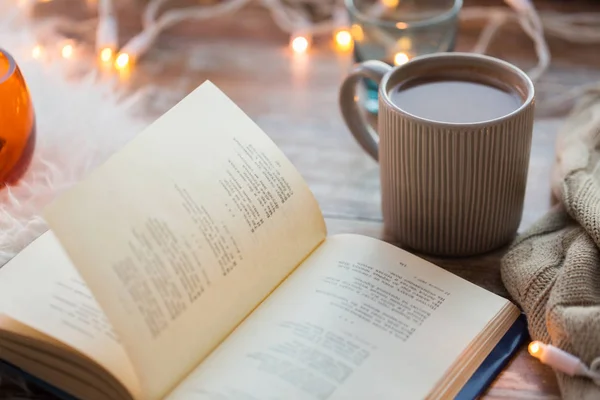 Libro y taza de café o chocolate caliente en la mesa — Foto de Stock