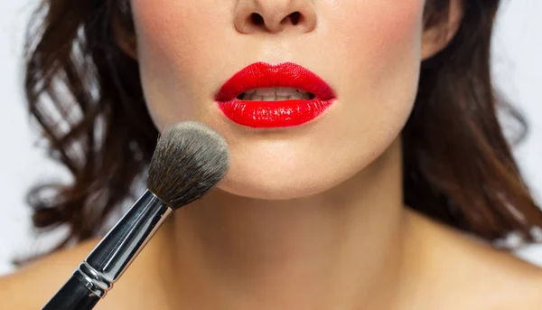 Cara de mujer con lápiz labial rojo aplicando polvo — Foto de Stock