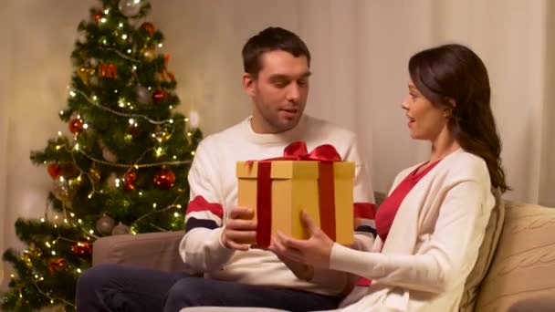 Pareja feliz con regalo de Navidad en casa — Vídeos de Stock