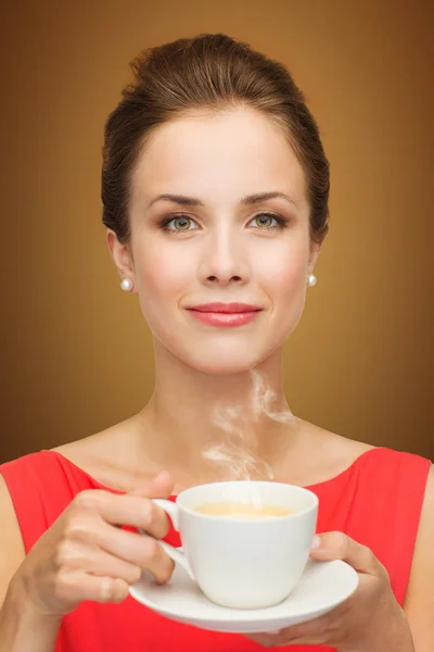 Bela mulher em vestido vermelho com xícara de café — Fotografia de Stock