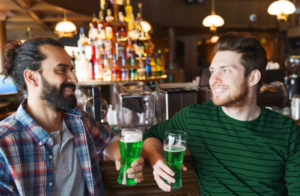 male friends drinking green beer at bar or pub