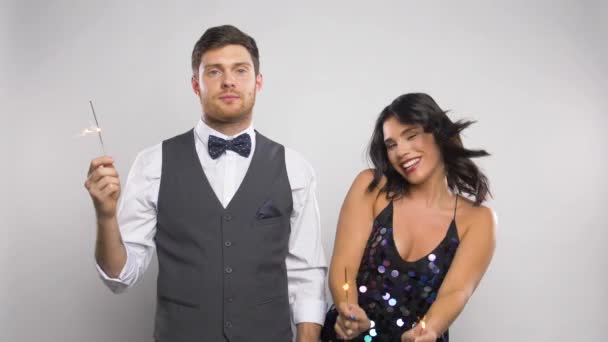 Mulher feliz com sparklers e homem entediado na festa — Vídeo de Stock
