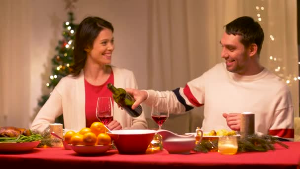 Счастливая пара пьет красное вино на рождественском ужине — стоковое видео