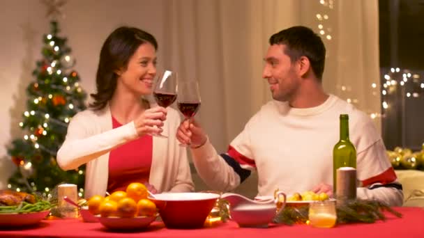 Glückliches Paar trinkt Rotwein beim Weihnachtsessen — Stockvideo