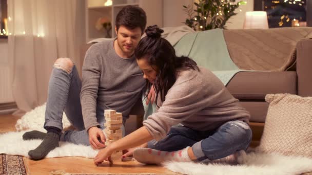 Feliz pareja jugando bloque-apilamiento juego en casa — Vídeos de Stock