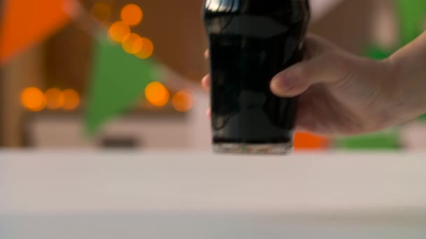Ręczne wprowadzenie szkła ciemne piwo na stole — Wideo stockowe