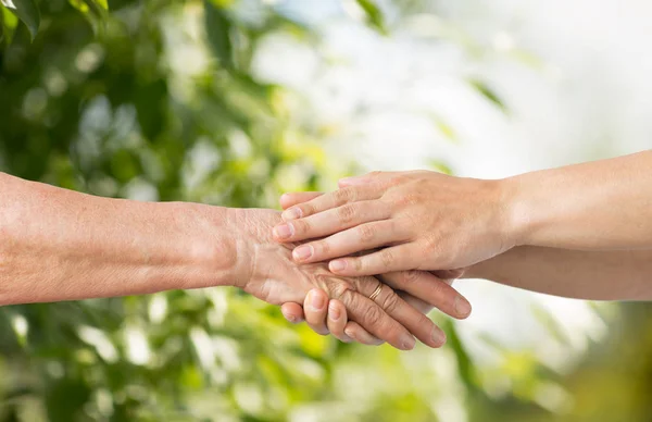 Närbild på senior och ung kvinna hand i hand — Stockfoto