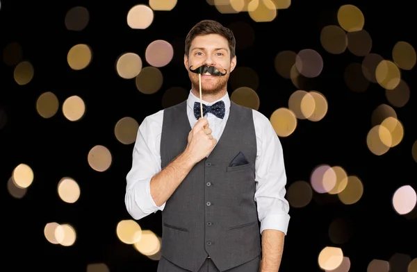 Happy young man with fake mustache at party — Stock Photo, Image