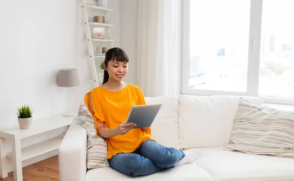 Szczęśliwa młoda kobieta Azji z komputera typu tablet w domu — Zdjęcie stockowe