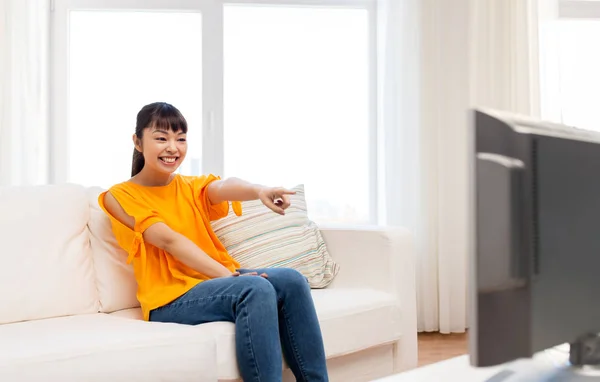 Feliz mulher asiática com assistindo tv em casa — Fotografia de Stock