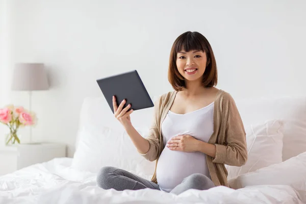 快乐的亚洲孕妇，家里有平板电脑 — 图库照片
