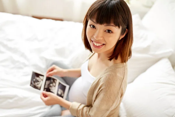 Zwangere vrouw met foetale echografie beeld thuis — Stockfoto
