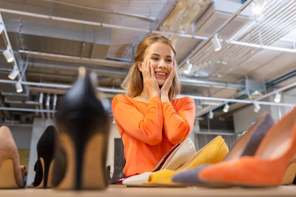 Mujer joven emocionada eligiendo zapatos en la tienda —  Fotos de Stock