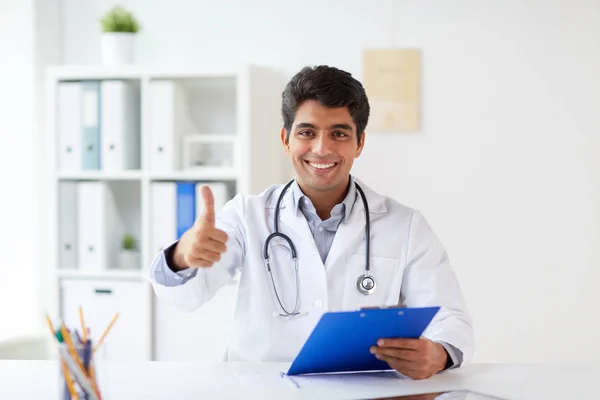 Щасливий лікар в клініці показує великі пальці вгору — стокове фото