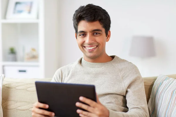 Uomo sorridente con tablet pc a casa — Foto Stock