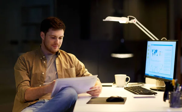 Homme d'affaires avec des papiers travaillant au bureau de nuit — Photo