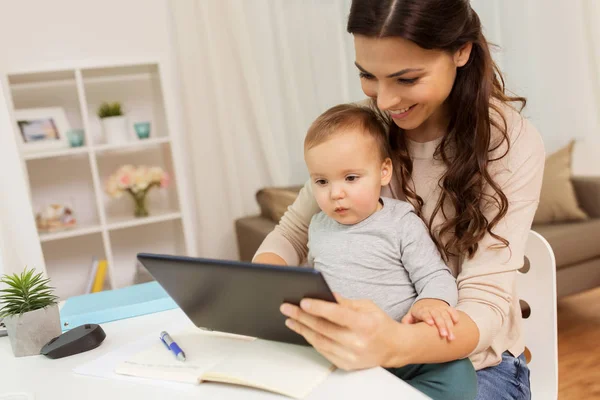Mère étudiante avec bébé et tablette pc à la maison — Photo