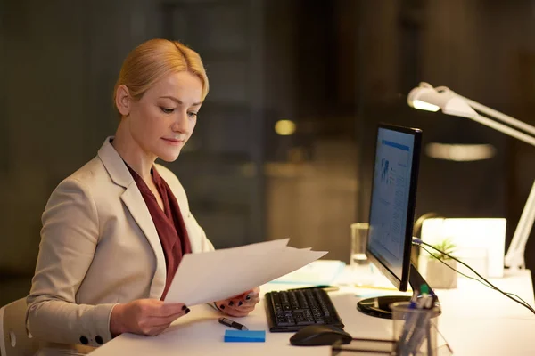 Mujer de negocios con papeles trabajando en la oficina nocturna — Foto de Stock