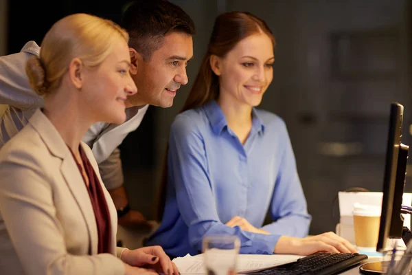 Team aziendale con computer che lavora fino a tardi in ufficio — Foto Stock