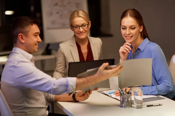 Business-team med papper som arbetar sent på kontoret — Stockfoto