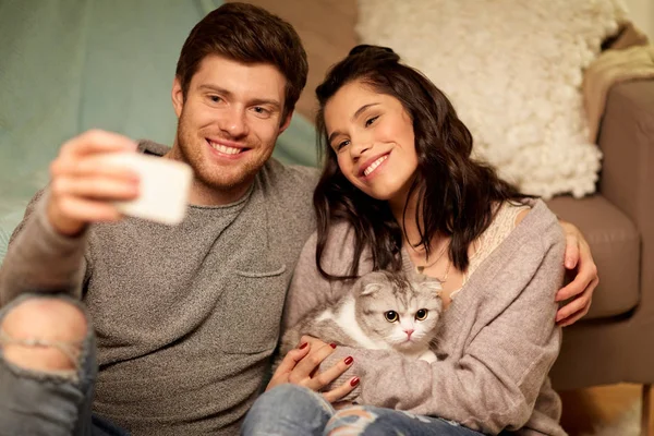 Šťastný pár pořizování selfie pomocí smartphone doma — Stock fotografie