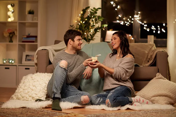 Feliz pareja con caja de regalo en casa — Foto de Stock