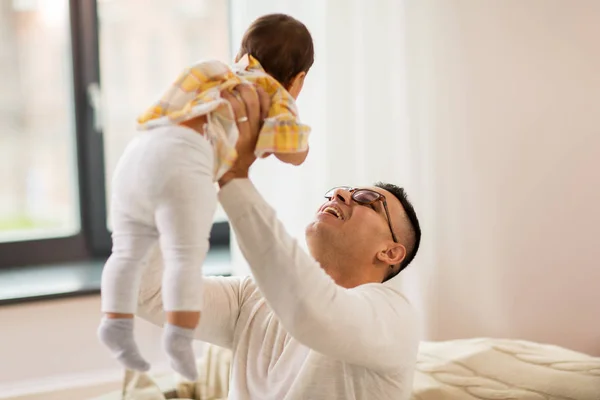 Feliz padre sosteniendo pequeño bebé hija en casa — Foto de Stock