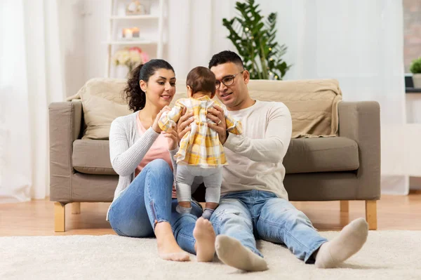 Onnellinen perhe vauvan tyttären kanssa kotona — kuvapankkivalokuva